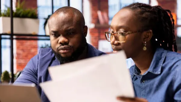 A couple working on a laptop in an office — an article about AI data analysis for Nigerian businesses