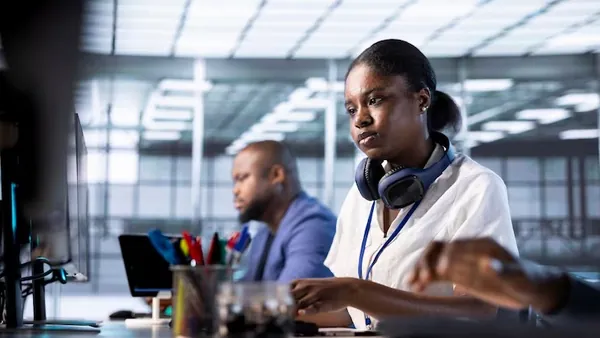 Business colleagues working in an office — an article about AI for customer retention in Nigeria