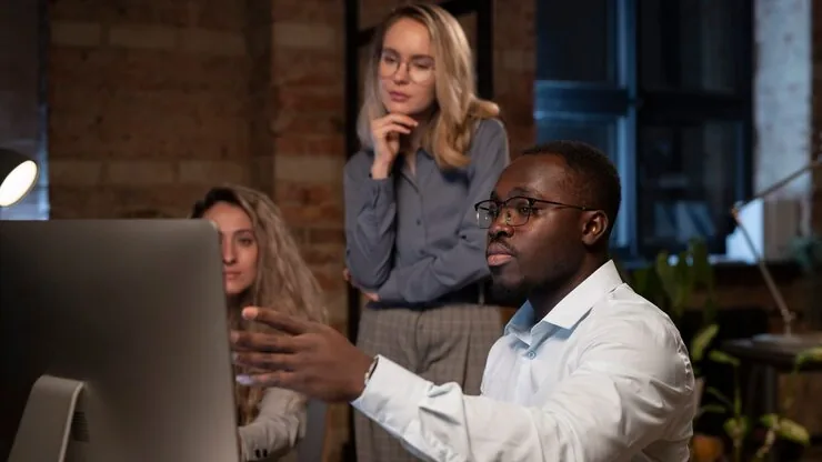Business colleagues at work at a computer in an office — an article about AI for Nigerian distributors