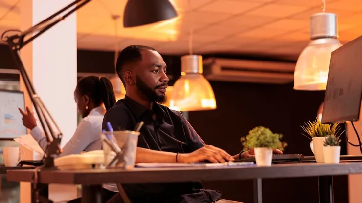 A businessman reviewing at a computer in an office — an article about AI for Nigerian law firms