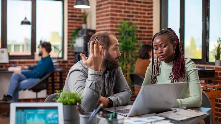 Business colleagues reviewing on a laptop in an office — an article about AI for Nigerian restaurants