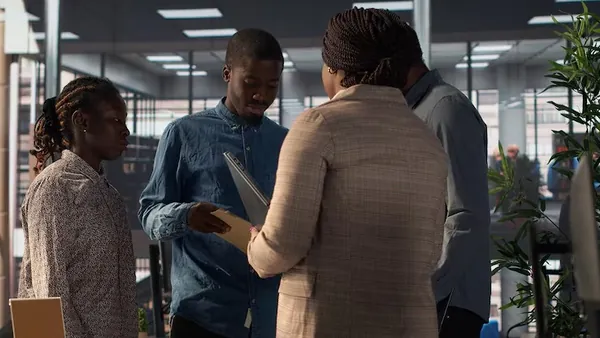 Business colleagues reviewing over documents in an office — an article about AI forecasting for Nigerian businesses