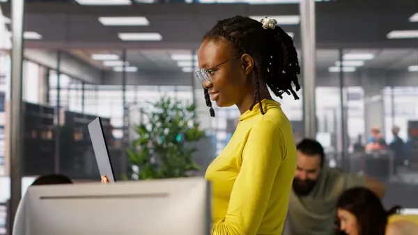 Business colleagues working on a laptop in an office — an article about AI fraud detection Nigeria