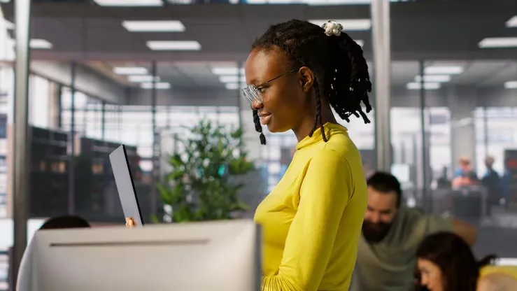 Business colleagues working on a laptop in an office — an article about AI fraud detection Nigeria
