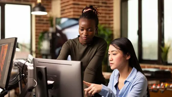 Business colleagues reviewing at a computer in an office — an article about AI inventory forecasting Nigeria
