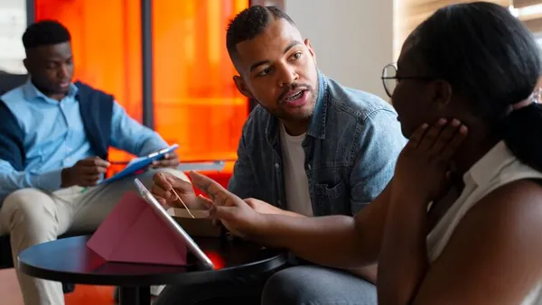 Business colleagues working in an office — an article about AI maintenance cost in Nigeria