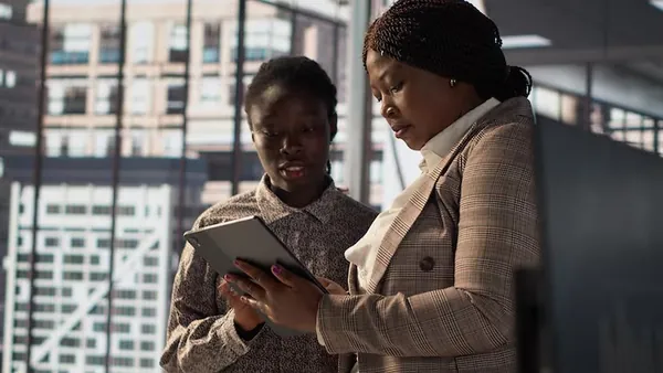 Business colleagues reviewing over documents in an office — an article about automating business reporting in Nigeria