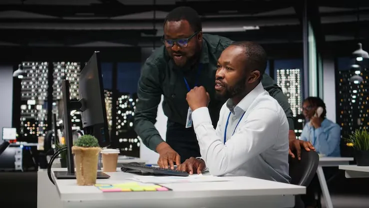 African business colleagues reviewing over documents in an office — an article about automating data entry in Nigeria