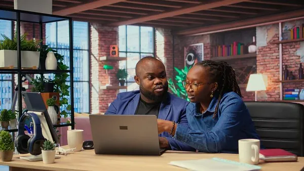 Business colleagues working on a laptop in an office — an article about booking software for Nigerian businesses