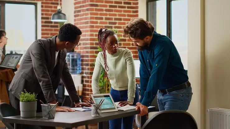 Business colleagues reviewing with a tablet in an office — an article about business KPIs Nigerian SMEs should track