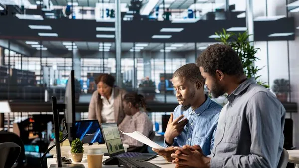 African business colleagues working over documents in an office — an article about church management software in Nigeria