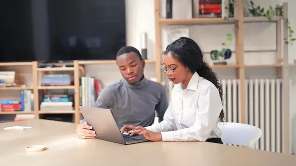 Business colleagues working at a computer in an office — an article about construction website design in Nigeria