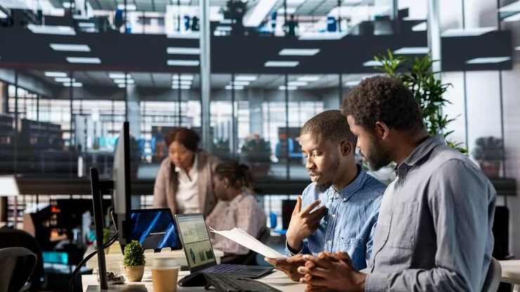 African business colleagues working over documents in an office — an article about customer management software for Nigerian