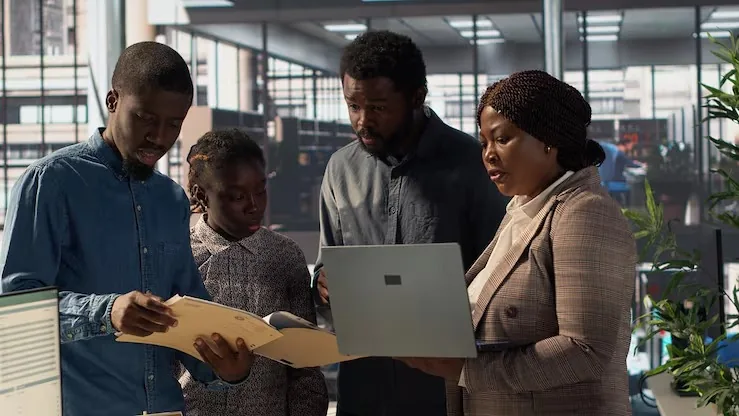 Business colleagues reviewing over documents in an office — an article about data analytics services in Nigeria