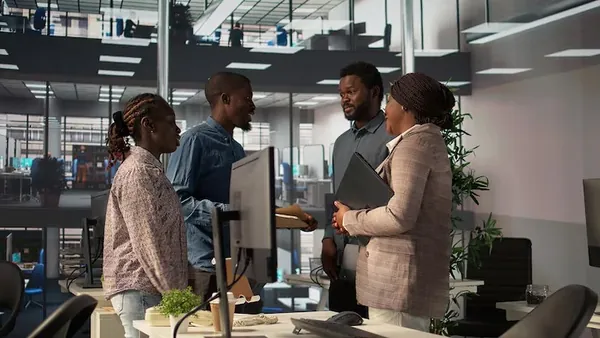 Business colleagues reviewing over documents in an office — an article about delivery tracking software in Nigeria