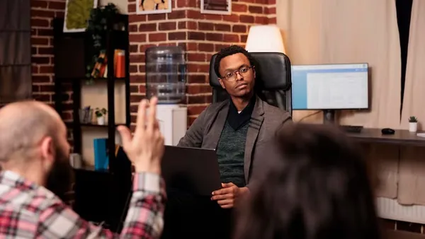 African business colleagues working on a laptop in an office — an article about e-commerce app development in Nigeria