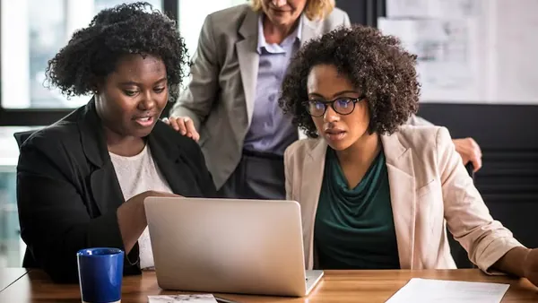 A businesswoman working on a laptop in an office — an article about hospital website design Nigeria