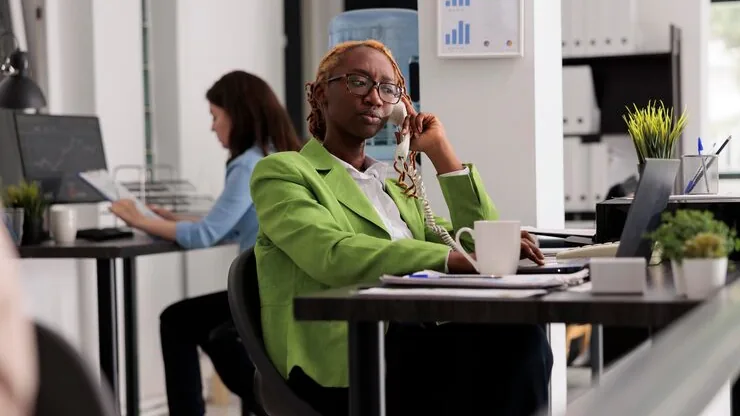 Business colleagues in a meeting on a phone at home — an article about cost to build a booking app in Nigeria