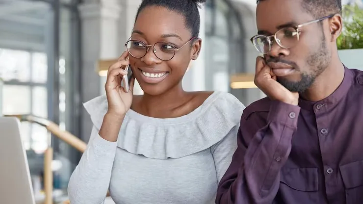 An African businesswoman on a call on a laptop in an office — an article about cost to build a customer portal app