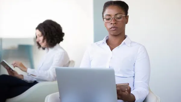 A businesswoman working on a laptop in an office — an article about cost to build a healthcare app in Nigeria