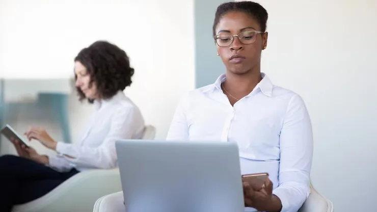 A businesswoman working on a laptop in an office — an article about cost to build a healthcare app in Nigeria
