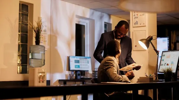 Business colleagues in a meeting over documents in an office — an article about cost to build a startup in Nigeria