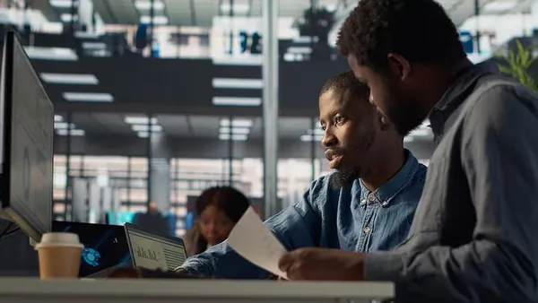 A manager working at a computer in an office — how much should a Nigerian business spend on technology