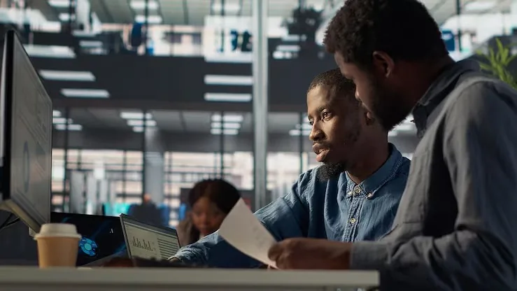 A manager working at a computer in an office — how much should a Nigerian business spend on technology