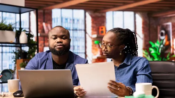 African business colleagues on a laptop at home — how to accept payment on a Nigerian website