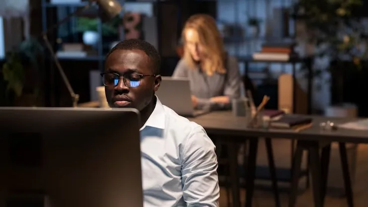 An African businessman working at a computer in an office — an article about add a customer portal to your website