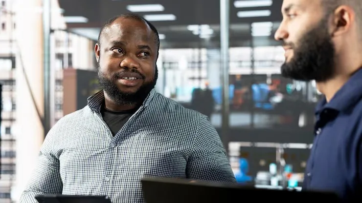 Business colleagues reviewing on a laptop in an office — an article about add Flutterwave to your website