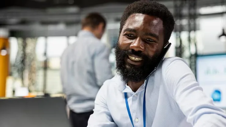 An African businessman on a call on a laptop in an office — an article about add online booking to your website