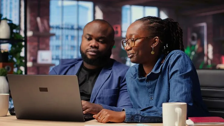 African business colleagues reviewing on a laptop at home — an article about add Stripe to a Nigerian website