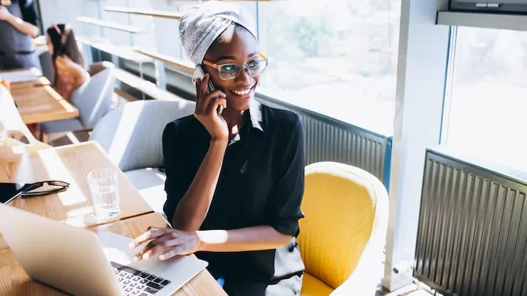 An African businesswoman on a call on a phone in an office — an article about automate WhatsApp orders