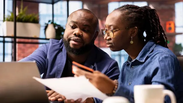 A couple working on a laptop in an office — how to budget for AI integration in Nigeria