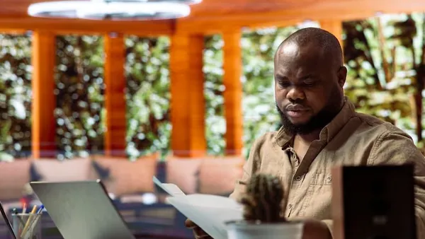 Business colleagues planning on a laptop in an office — how to budget for website development in Nigeria