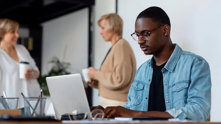 A businessman working on a laptop in an office — how to build a classified website in Nigeria