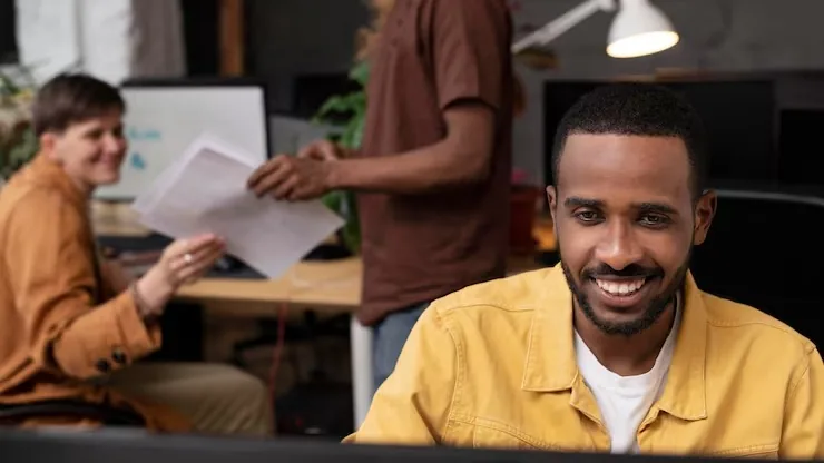 Business colleagues working at a computer in an office — how to build a directory website in Nigeria