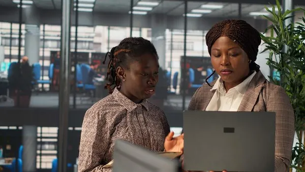 Business colleagues reviewing over documents in an office — an article about mobile app with biometric login