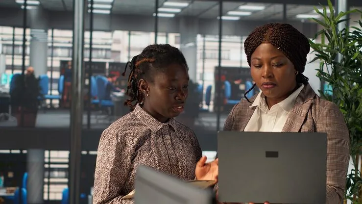Business colleagues reviewing over documents in an office — an article about mobile app with biometric login