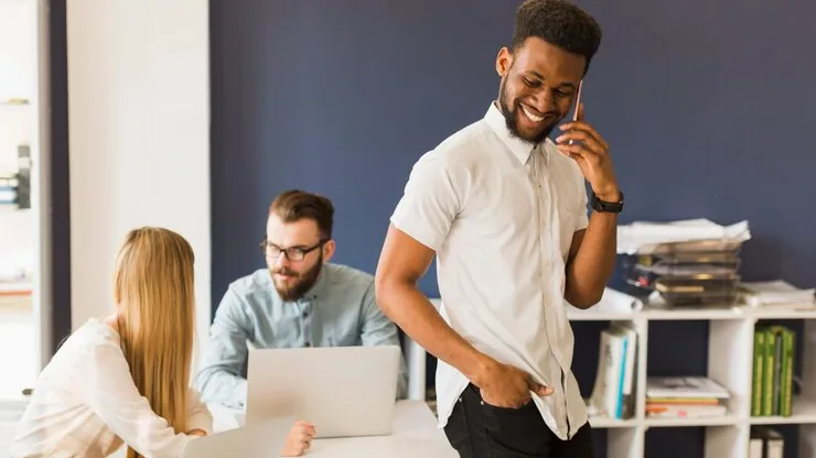 Business colleagues working on a phone in an office — an article about mobile app with multiple user roles