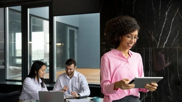 Business colleagues working on a laptop in an office — how to build a payment app in Nigeria