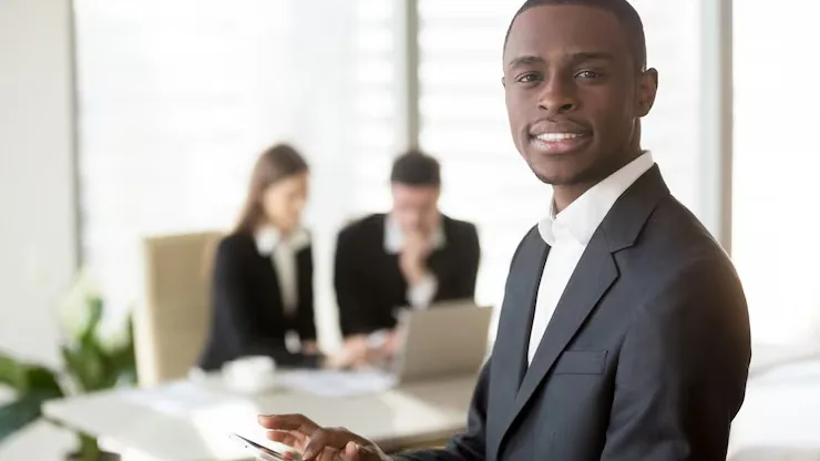 An African businessman in a meeting with a tablet in an office — how to find an app developer in Nigeria