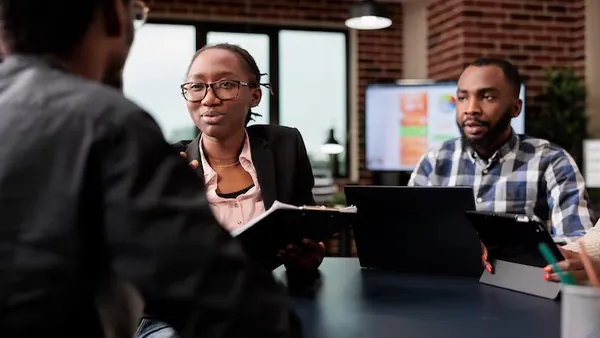 Business colleagues in a meeting over documents in an office — how to get your online store on Google