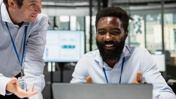 Business colleagues reviewing on a laptop in an office — how to improve customer service in Nigeria