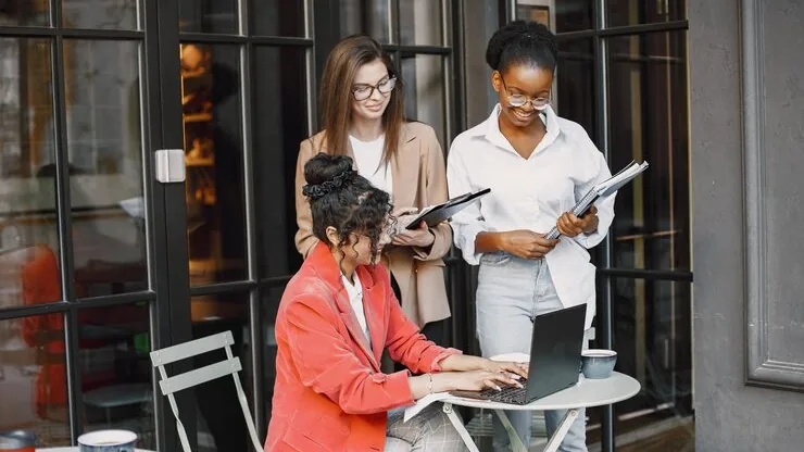 Business colleagues in a meeting over documents in a cafe — how to increase sales in Nigeria
