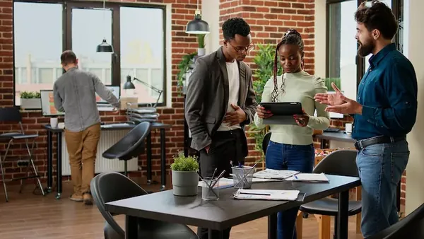 Business colleagues reviewing with a tablet in an office — how to maintain an app after launch