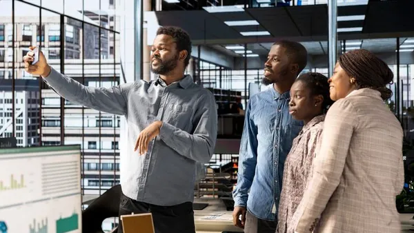 African business colleagues taking notes in an office — how to manage a software development project
