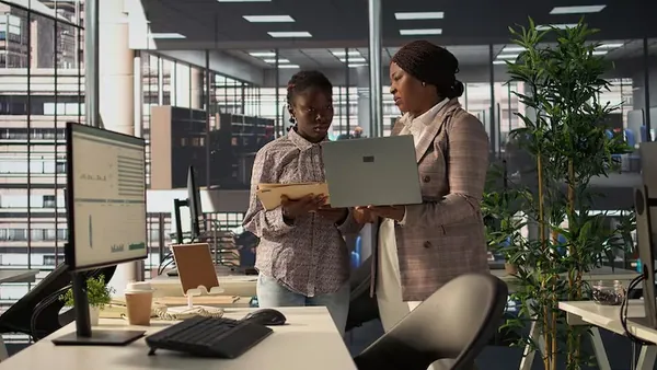 Business colleagues reviewing over documents in an office — how to measure app success