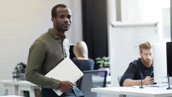 An African businessman working on a laptop in an office — how to own your website after development